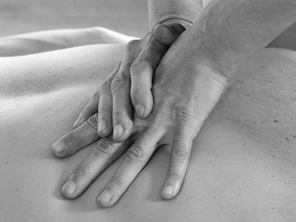 Mani che massaggiano la schiena